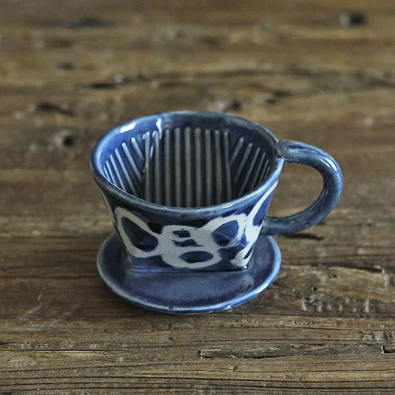 Blue & white ceramic dripper from hand-painted Japanese-style coffee & tea set on wood.